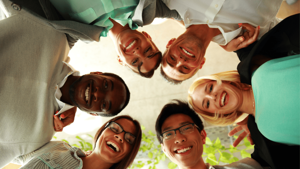 picture of people in a circle looking down while smiling