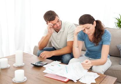 picture of a stressed couple looking at papers on a table
